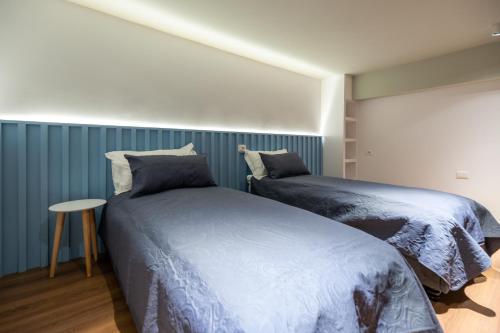 a bedroom with two beds and a small table at Spa & Pool - Studio Apartments 365 in Tirana