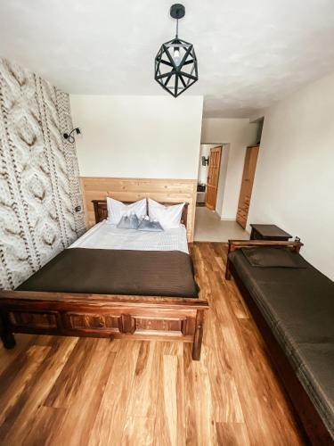 a bedroom with a large bed and a wooden floor at U Maćka in Białka Tatrzanska