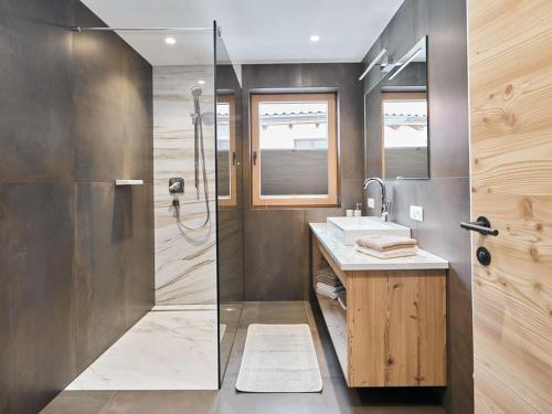 a bathroom with a shower and a sink and a mirror at Alpenchalet S´Andalr in Pfunds