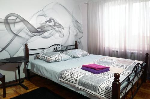 a bedroom with a bed with a painting on the wall at 2 Rooms Semi-luxury Apt on 39-H Nezalezhnoi Ukrаiny Street next to the city council (Walk of Fame) in Zaporozhye