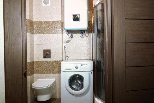 a small bathroom with a toilet and a washing machine at 2 Rooms Semi-luxury Apt on 39-H Nezalezhnoi Ukrаiny Street next to the city council (Walk of Fame) in Zaporozhye
