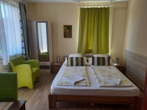 a bedroom with a bed and a green curtain at Médea Apartman in Bük