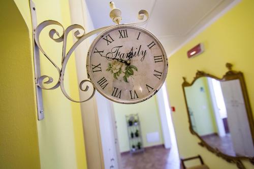 a clock hanging on a wall next to a mirror at Osteria da Cesare e Locanda in Castel San Pietro Terme