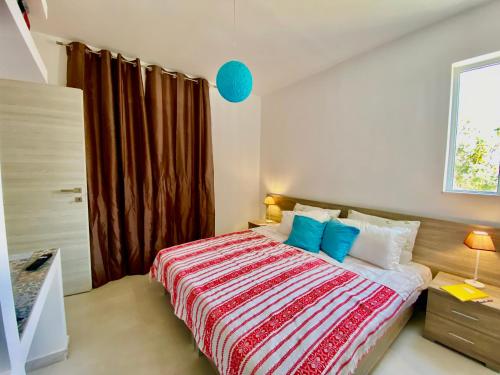 a bedroom with a large bed with blue pillows at Marmaraki Village House & Apartments in Kardamaina