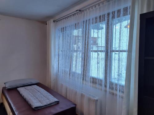 a bedroom with a window with curtains and a bench at Alina's DIY-Haus St.Jakob in Innere Großrotte