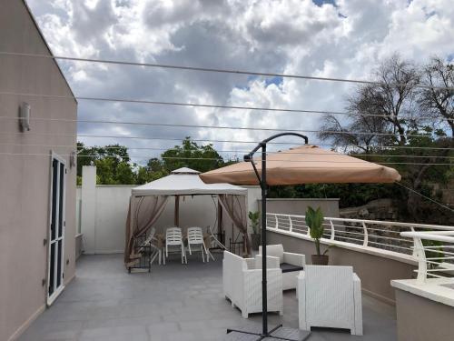 a patio with an umbrella and chairs on a balcony at Apulia Tourist Salento in Gemini