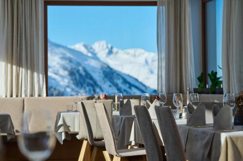 a dining room with a table with a mountain view at Alpenhotel Laurin in Hochgurgl