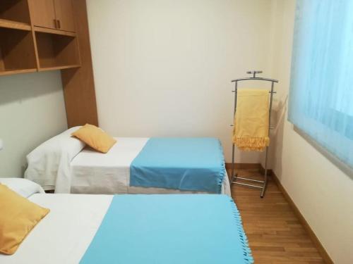 een kleine kamer met 2 bedden bij Apartamento Valleron in Foz