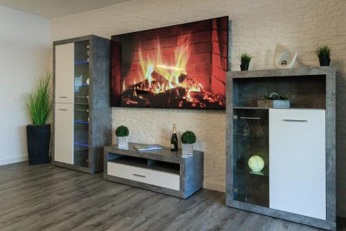 a fireplace in a living room with a fire in the wall at Relax-Apartment mit Indoor-Pool, Sauna, Massagesessel und Netflix in Schonach