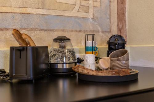 a counter with a blender and a plate of food at Ladiri - Antica dimora in terra cruda in Sìnnai