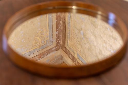 a close up of a mirror looking at a building at Ladiri - Antica dimora in terra cruda in Sìnnai