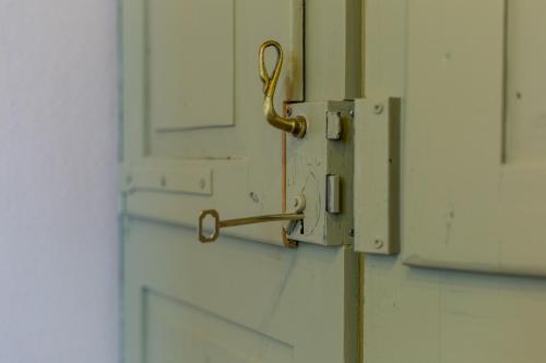 ajar door with a metal latch on a door at Ladiri - Antica dimora in terra cruda in Sìnnai