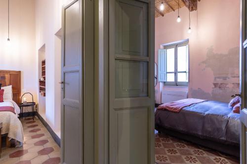 a room with a door leading to a bed at Ladiri - Antica dimora in terra cruda in Sìnnai
