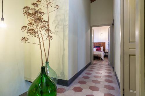 a hallway with two green vases sitting on a floor at Ladiri - Antica dimora in terra cruda in Sìnnai