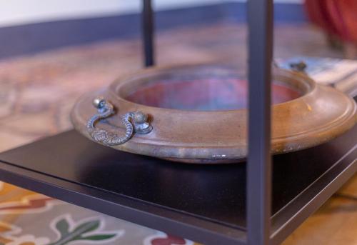 a wooden bowl sitting on a black table at Ladiri - Antica dimora in terra cruda in Sìnnai