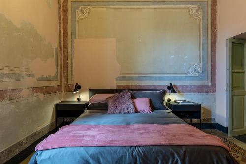 a bedroom with a large bed with two night stands at Ladiri - Antica dimora in terra cruda in Sìnnai