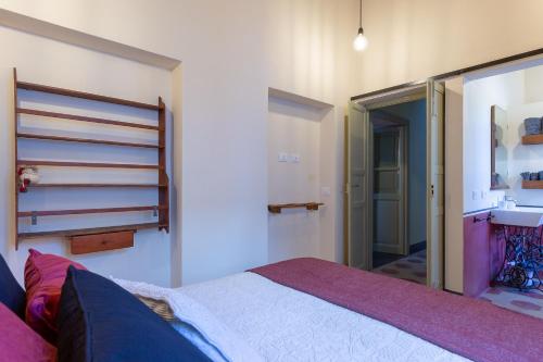 a bedroom with a bed and a sink at Ladiri - Antica dimora in terra cruda in Sìnnai