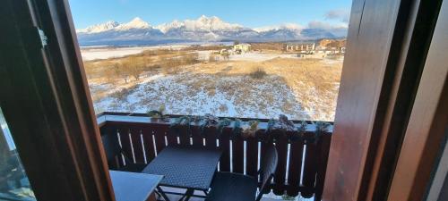 a balcony with a table and a view of snow covered mountains at Sunset View in Kežmarok