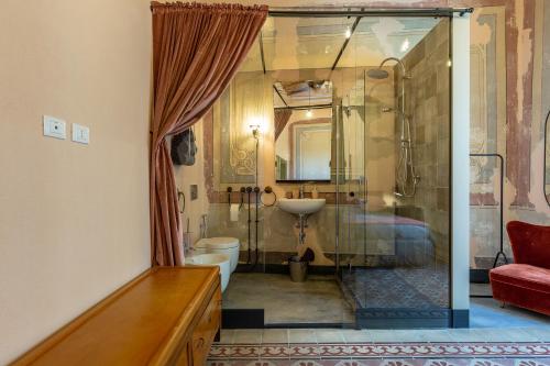 a bathroom with a shower and a toilet and a sink at Ladiri - Antica dimora in terra cruda in Sìnnai