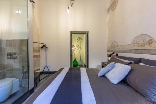 a bedroom with a large bed and a bath tub at Ladiri - Antica dimora in terra cruda in Sìnnai