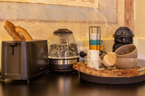 a counter top with a coffee maker and some food at Ladiri - Antica dimora in terra cruda in Sìnnai