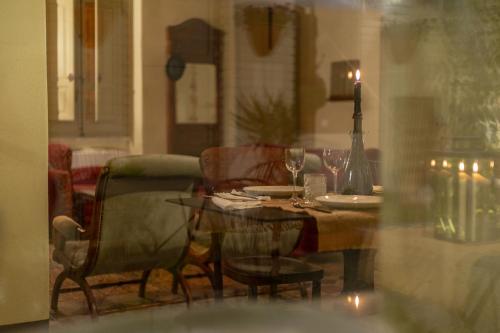 a dining room table with a candle and a table and chairs at Ladiri - Antica dimora in terra cruda in Sìnnai