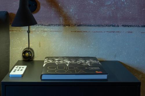 a book on a table with a lamp and a clock at Ladiri - Antica dimora in terra cruda in Sìnnai