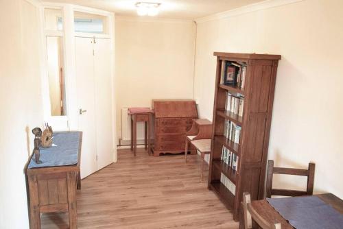 a living room with a table and a book shelf at Spacious 1bed flat in Cambridge near Chesterton in Cambridge
