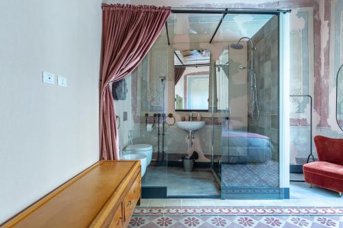 a bathroom with a shower and a toilet and a sink at Ladiri - Antica dimora in terra cruda in Sìnnai