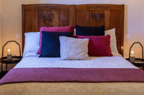 a bedroom with a large bed with purple sheets and pillows at Ladiri - Antica dimora in terra cruda in Sìnnai