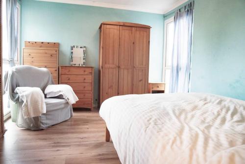 a bedroom with a bed and a chair and a dresser at Spacious 1bed flat in Cambridge near Chesterton in Cambridge