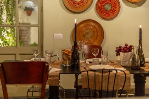 a dining room table with candles and plates and chairs at Ladiri - Antica dimora in terra cruda in Sìnnai