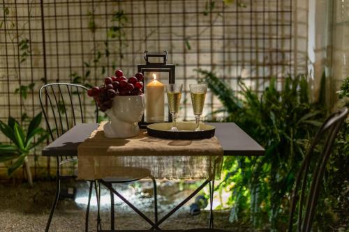 a table with two glasses of wine and a candle at Ladiri - Antica dimora in terra cruda in Sìnnai