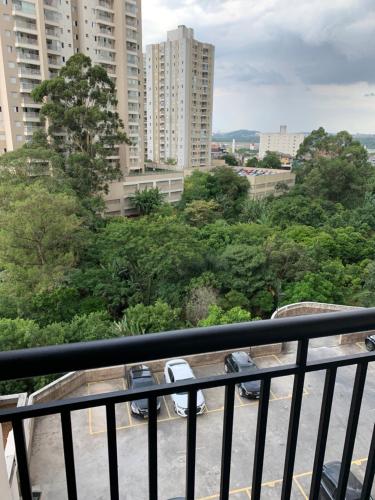 uma varanda com vista para árvores e edifícios em Quartos Vila Augusta/Guarulhos em Guarulhos