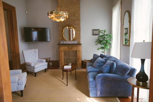 a living room with a blue couch and a mirror at PAUSED - Miss Ruby's Mid-City in New Orleans