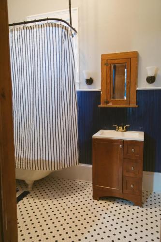 a bathroom with a shower and a sink and a mirror at PAUSED - Miss Ruby's Mid-City in New Orleans