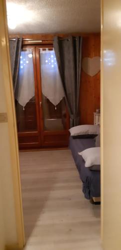 a room with two beds and windows with curtains at Valloire Studio Marmotte : Nid douillet centre de valloire, été / hiver 4p in Valloire