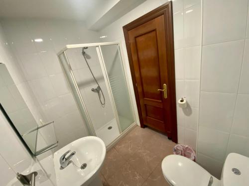 a bathroom with a toilet and a sink and a shower at Hotel CASA DEMA in Fresneda