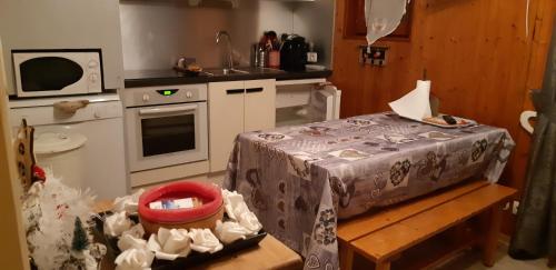 une petite cuisine avec une table et un évier dans l'établissement Valloire Studio Marmotte : Nid douillet centre de valloire, été / hiver 4p, à Valloire