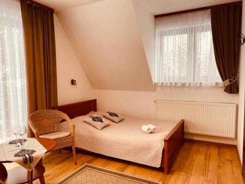 a small bedroom with a bed and a chair at szymkówka in Białka Tatrzańska