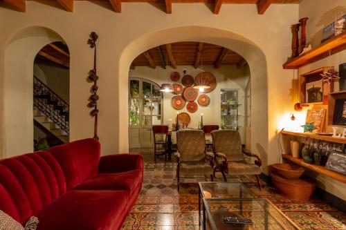 a living room with a red couch and a table at Ladiri - Antica dimora in terra cruda in Sìnnai
