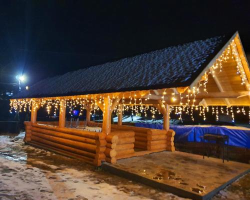 einen hölzernen Pavillon mit Weihnachtslichtern in der Unterkunft Casa Edi in Poiana Negrii
