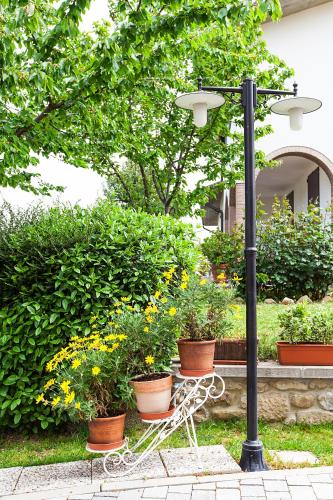 a bench sitting next to a light pole with plants at Osteria da Cesare e Locanda in Castel San Pietro Terme