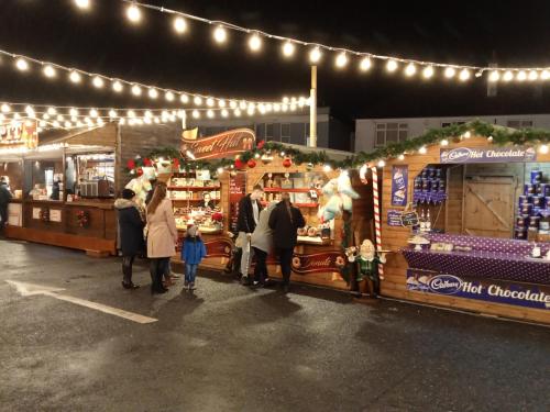 a group of people standing in front of a christmas market at Glorious Duplex Holiday Apartment By The Sea in Bognor Regis