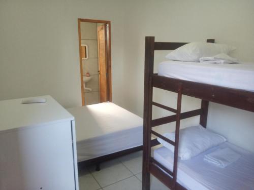 a room with two bunk beds and a refrigerator at Casa do Mochileiro Airport Hostel & Pousada in São Gonçalo do Amarante