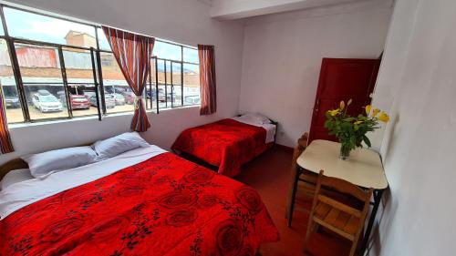 1 dormitorio con cama, mesa y ventana en SK Hostal en Cuzco