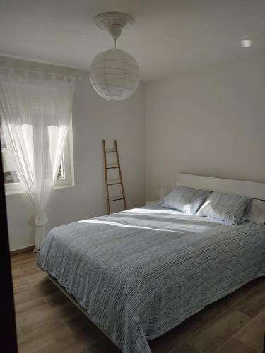ein Schlafzimmer mit einem Bett, einer Leiter und einem Fenster in der Unterkunft Mi Piso en Béjar in Béjar