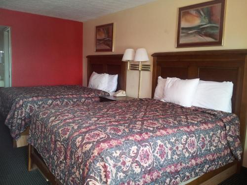 a hotel room with two beds and two lamps at Garden Inn and Extended Stay in Shepherdsville