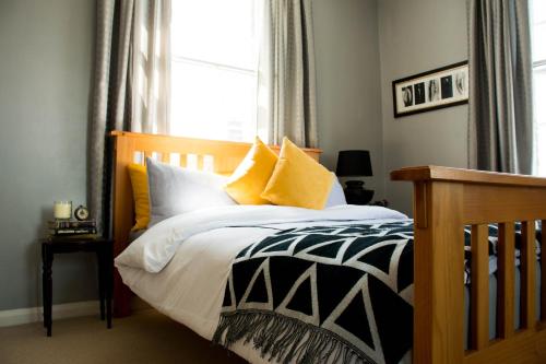 a bedroom with a bed with yellow and white pillows at Characterful Abode with FREE parking. in Liverpool