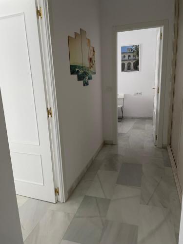 a hallway with white walls and a tile floor at Piso a 60 metros de la Catedral in Seville